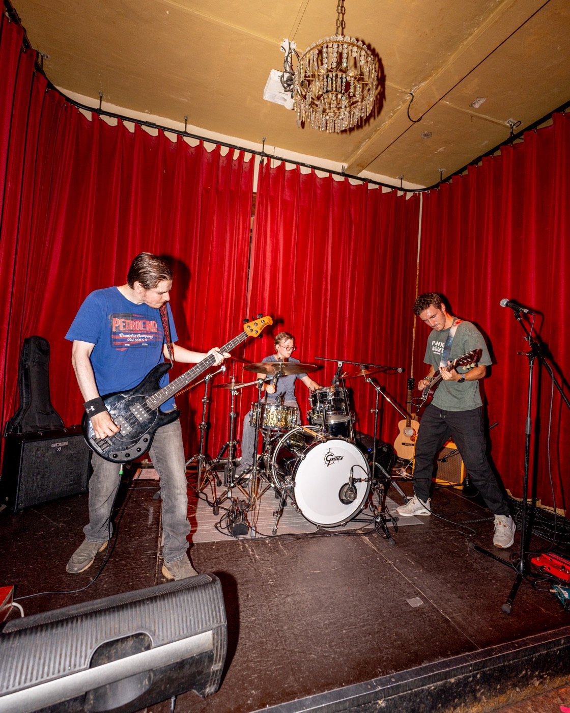 On Hold playing live under red stage curtains